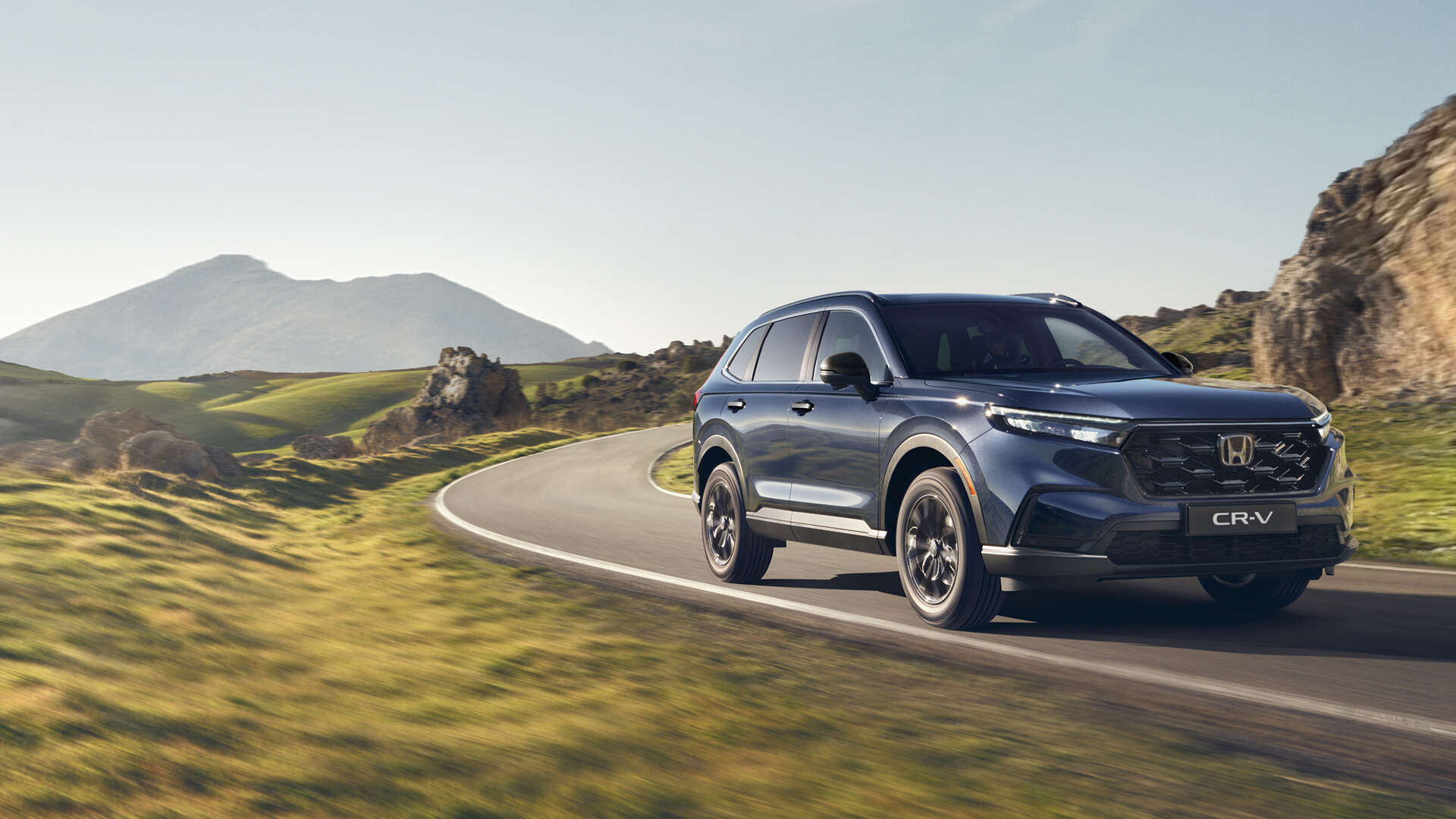 CR-V Plug in Hybrid Suv car driving on the road in a mountain location.